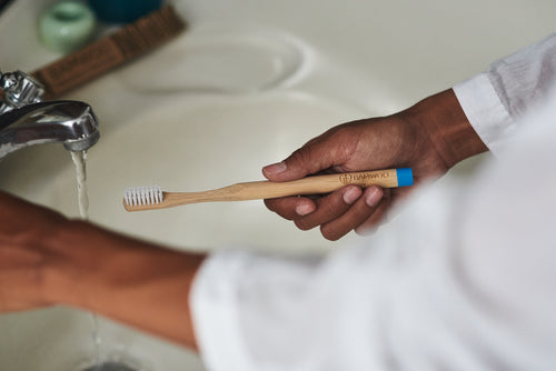 Girl brushing her teeth with a BAMWOO bamboo toothbrush in a villa in Bali, Indonesia