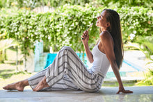 Smiling girl sits next to the pool in Bali with a BAMWOO bamboo toothbrush