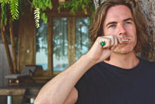 Man brushing his teeth with a BAMWOO bamboo toothbrush at The Seraya, a tropical island in Flores, Indonesia