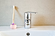 Child's dawn purple bamboo toothbrush from BAMWOO on sink in bathroom