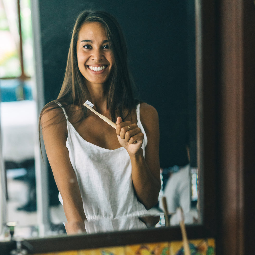 Using a biodegradable bamboo toothbrush